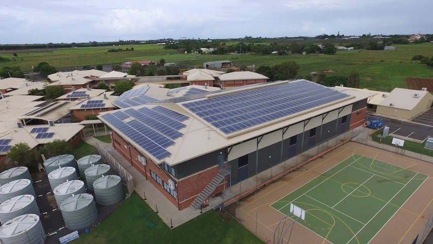 Aerial shot of the Bundaberg Christian College showing several large brick buildings with solar panels all over the roofs.