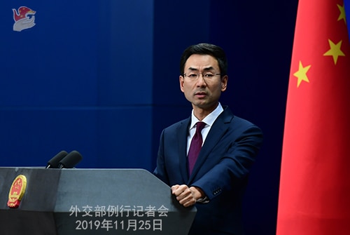 Geng Shuang stands at a podium.