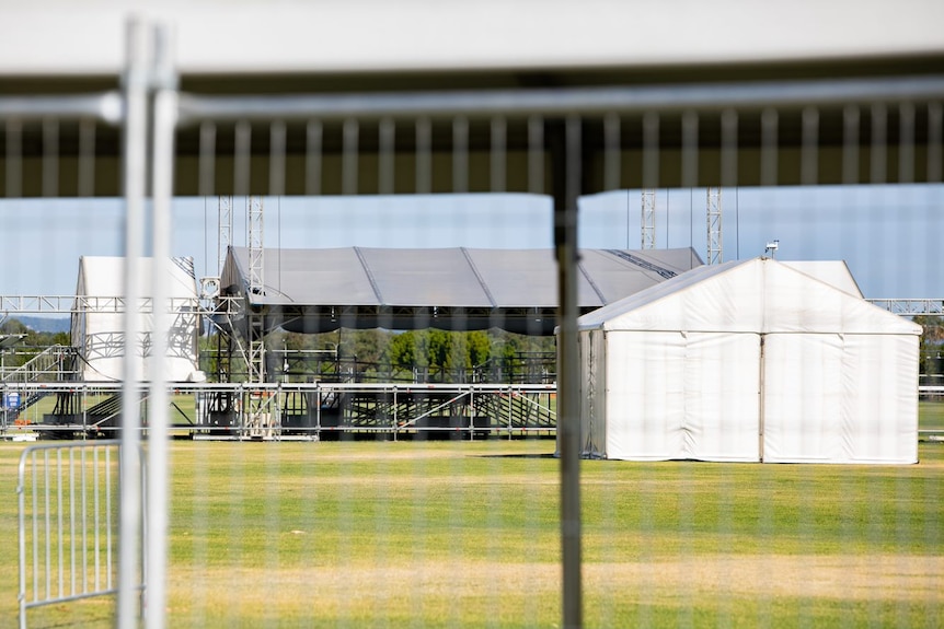 A wide shot of a white marquee and stage on an oval. 