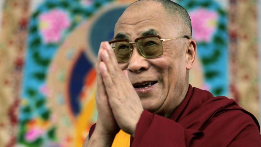 The Dalai Lama gestures during a public meeting.