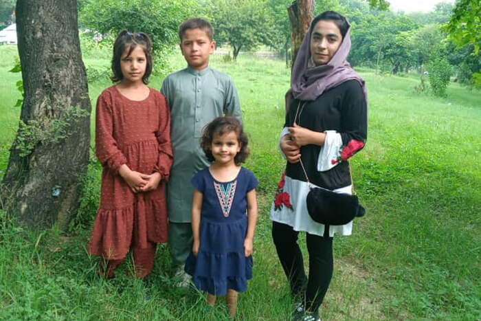 Latifa standing in a field with three children. 