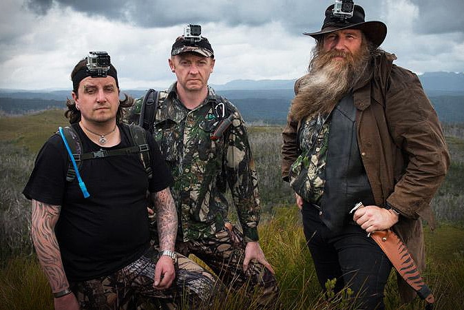 Chris Coupland, Warren Darragh and Bill Flowers pose for a photo on a cliff.