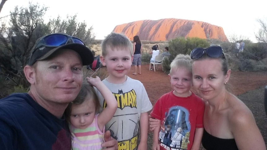 A family in front of Uluru.