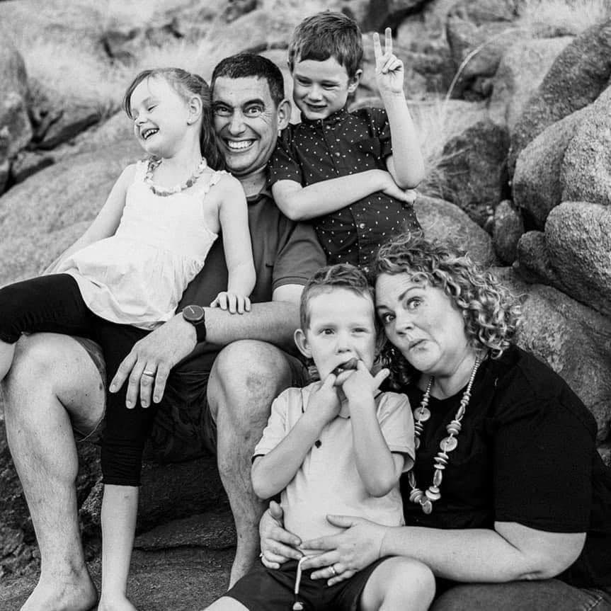 A black and white professional photo of a family making silly faces