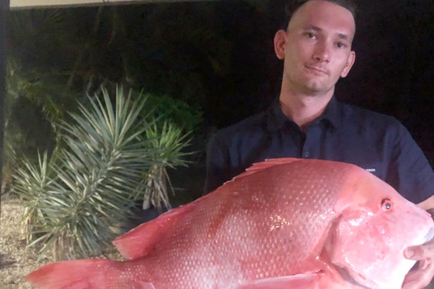 Cody Smith holds a big red fish.