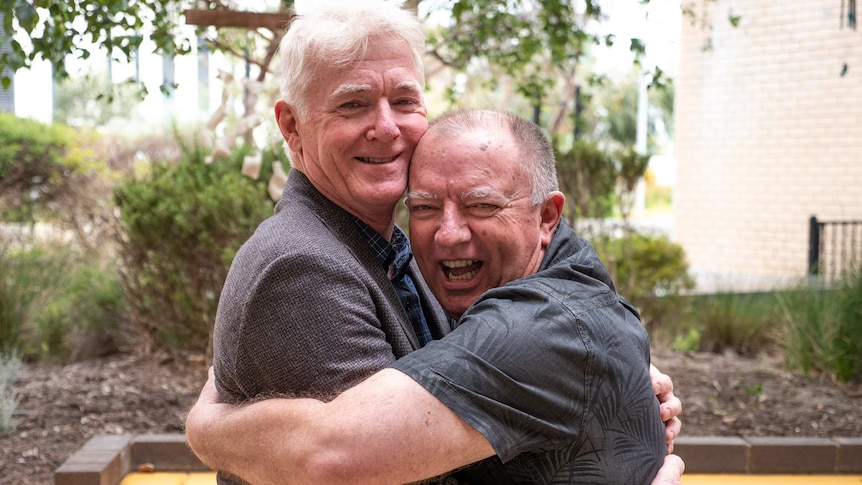 Professor Robert Larbalestier is embraced by first heart transplant patient, Rodney Western, both smiling.