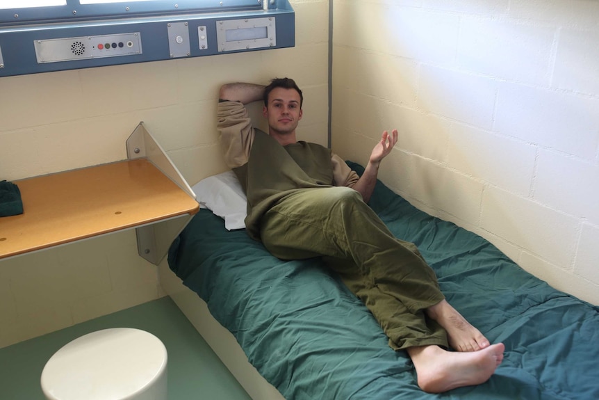 Timothy Swanston lying on a bed in a cell at Borallon Correctional Centre