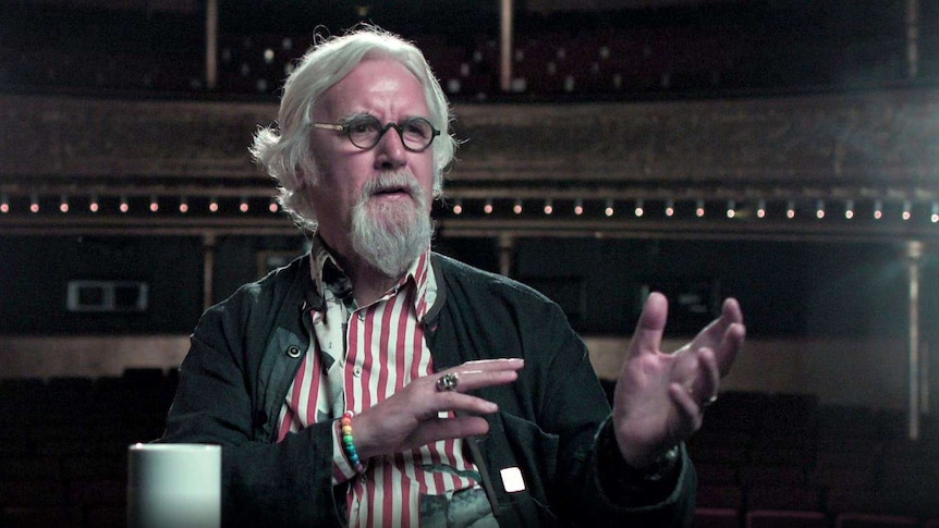 Sir Billy Connolly raises his hands as he is interviewed