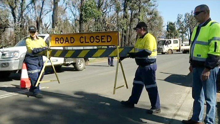 Road closure signs into the town of Yarloop are removed