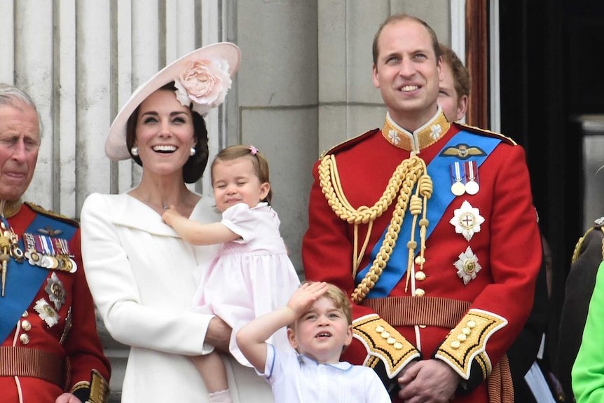 Queen Elizabeth and other members of the royal family stand on the balcony of Buckingham Palace.