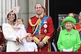 Queen Elizabeth and other members of the royal family stand on the balcony of Buckingham Palace.