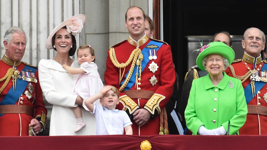 Queen Elizabeth and other members of the royal family stand on the balcony of Buckingham Palace.