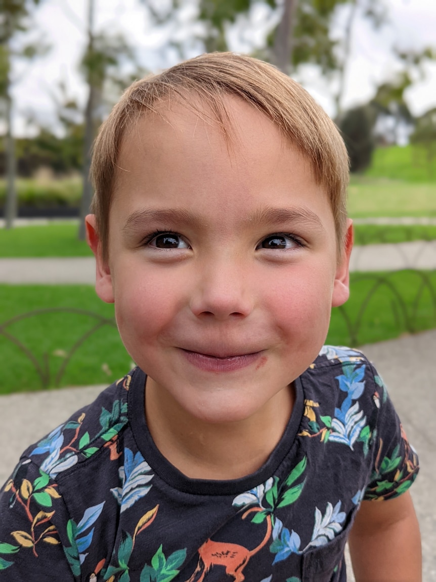 A photo of a young boy smiling up close to the camera