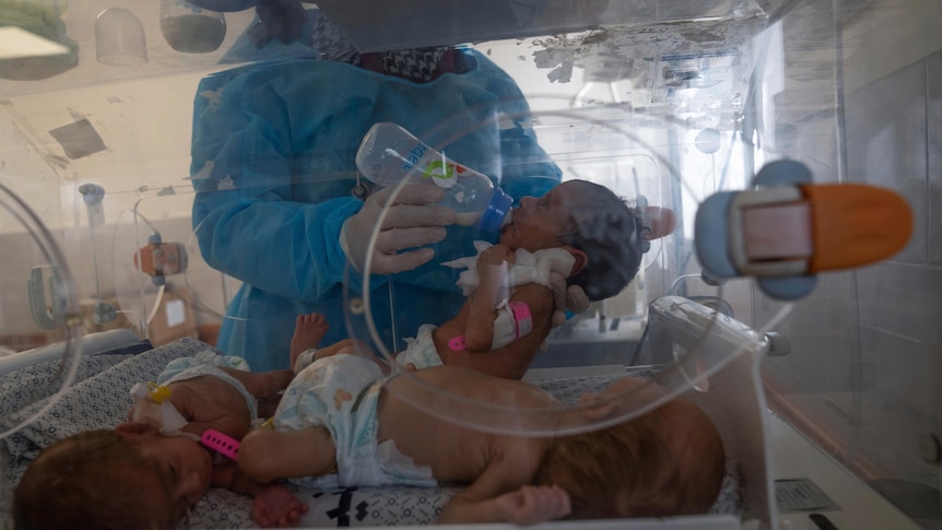 A nurse prepares premature babies for transport to Egypt after they were evacuated from Shifa Hospital.
