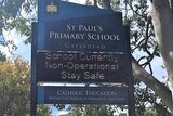 A sign outside a school reads "School currently non-operational".