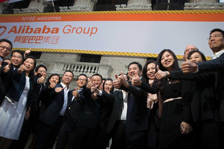 Założyciel Alibaba Group Holding Ltd Jack Ma (w środku) i Joseph Tsai (w środku L), wiceprezes i współzałożyciel, pozują z pracownikami przybywających na pierwszą ofertę publiczną firmy (IPO) na nowojorskiej giełdzie papierów wartościowych w Nowym Jorku 19 września 2014.
