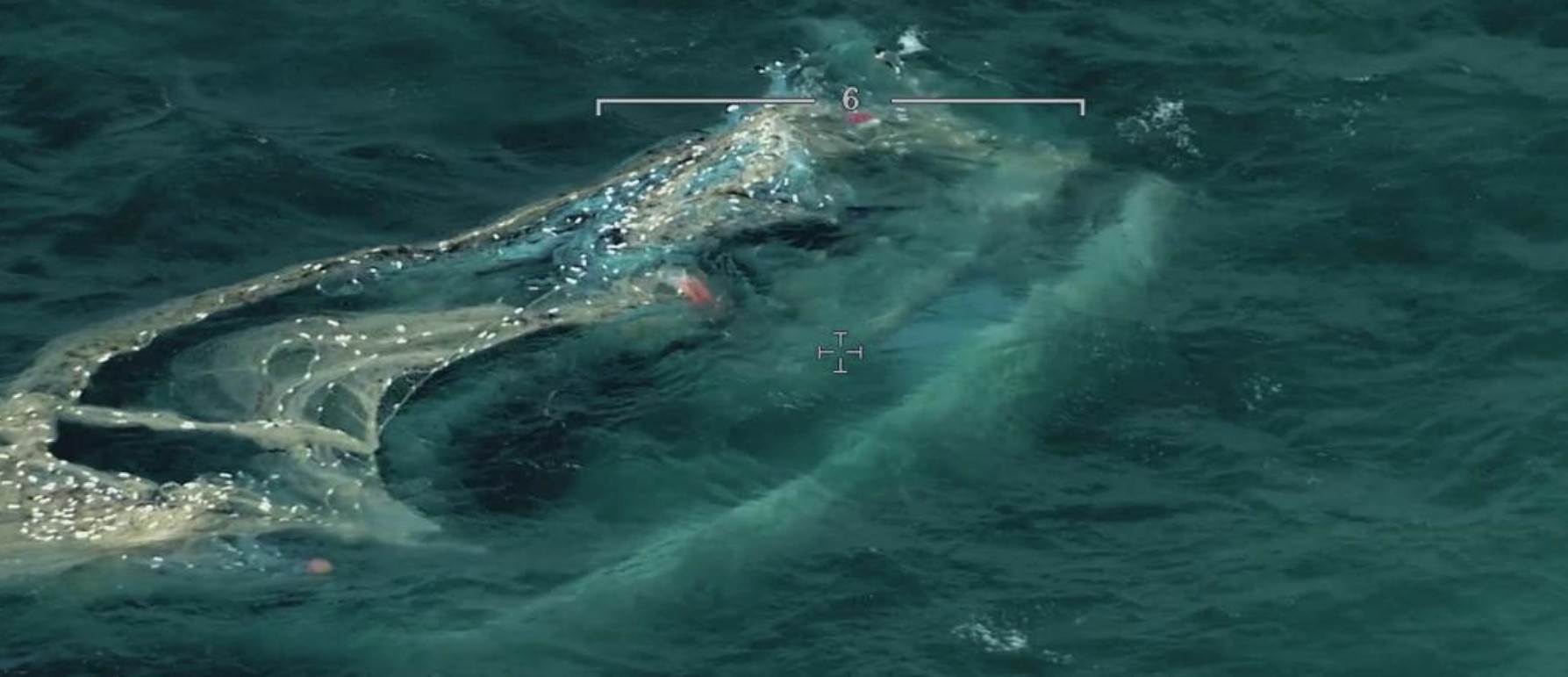 Un barco, casi sumergido, fotografiado desde el aire.