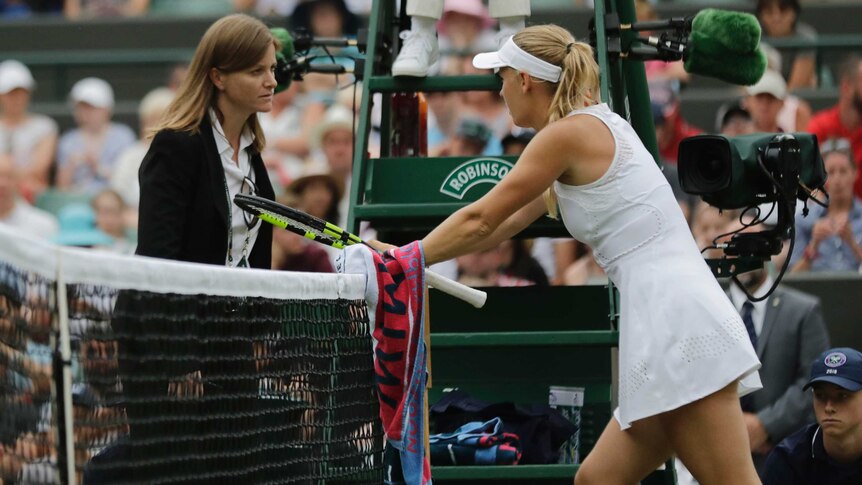 Caroline Wozniacki of Denmark talks to the match referee at Wimbledon on July 4, 2018.