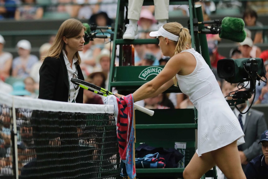 Caroline Wozniacki of Denmark talks to the match referee at Wimbledon on July 4, 2018.