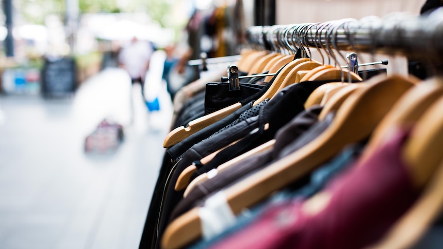 Racks of shirts in an op shop, it's best to donate clothes that are in good condition and not in need of repair.