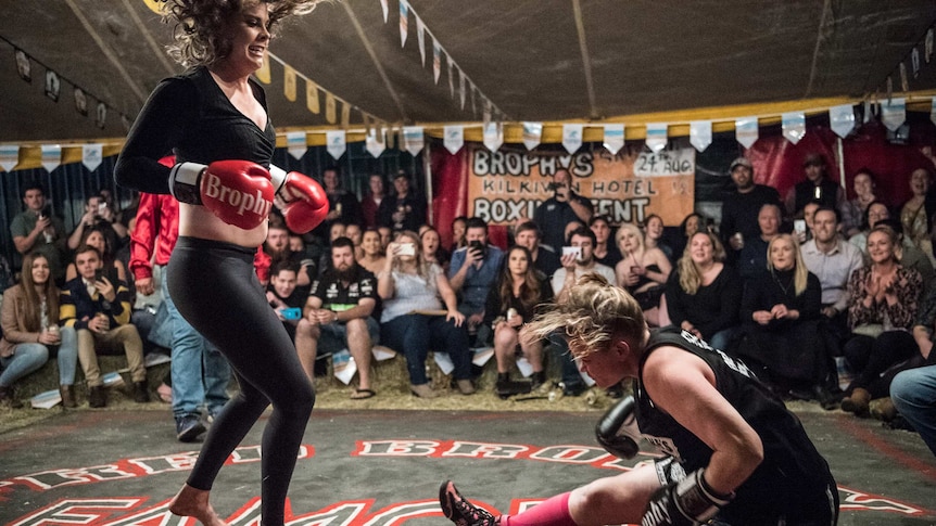 Two women take part in a boxing match, inside the Fred Brophy boxing tent in Mt Isa.