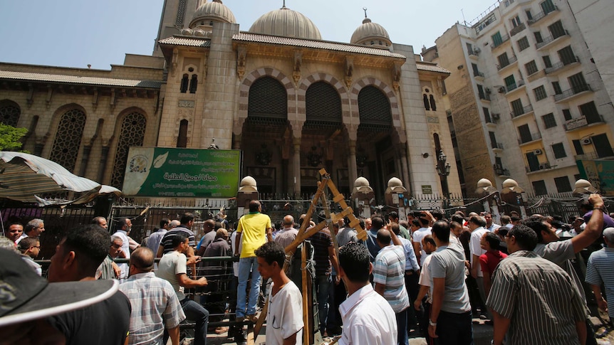 Anti-Morsi protesters and riot police officers gather outside Al-Fath mosque in Cairo