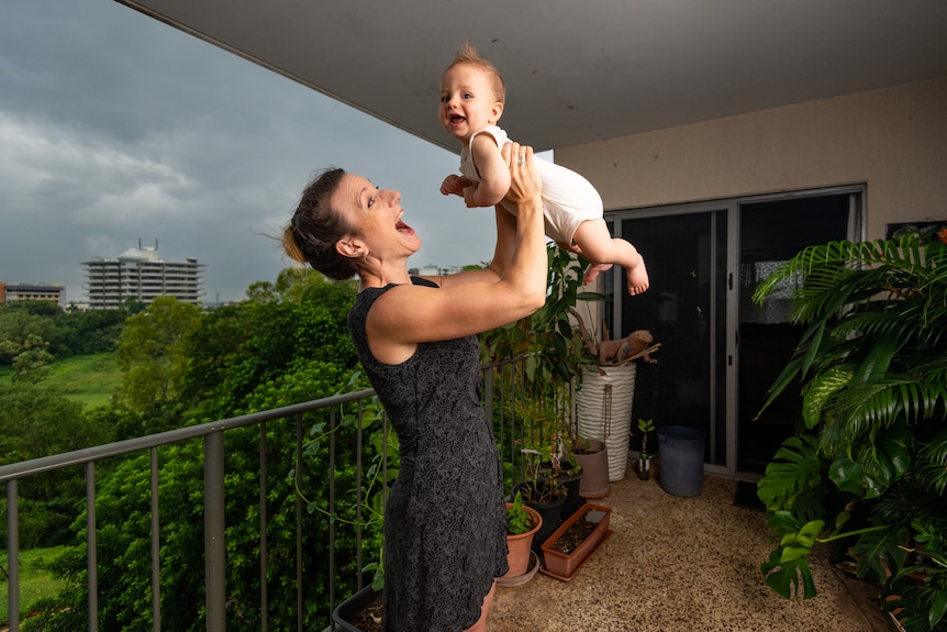 Darwin mum Aneeta Clark, holding her baby son Chesney, standing outside.