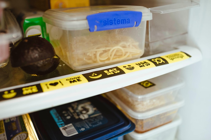 Du ruban adhésif noir et jaune dans un réfrigérateur rempli de nourriture