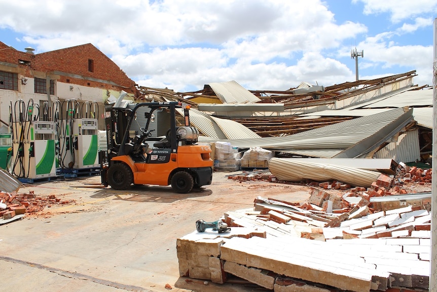 Pile of tin, bricks, and timber lay where a building used to stand