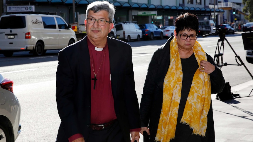 The Archbishop of Perth Roger Herft arrives at court with a supporter.