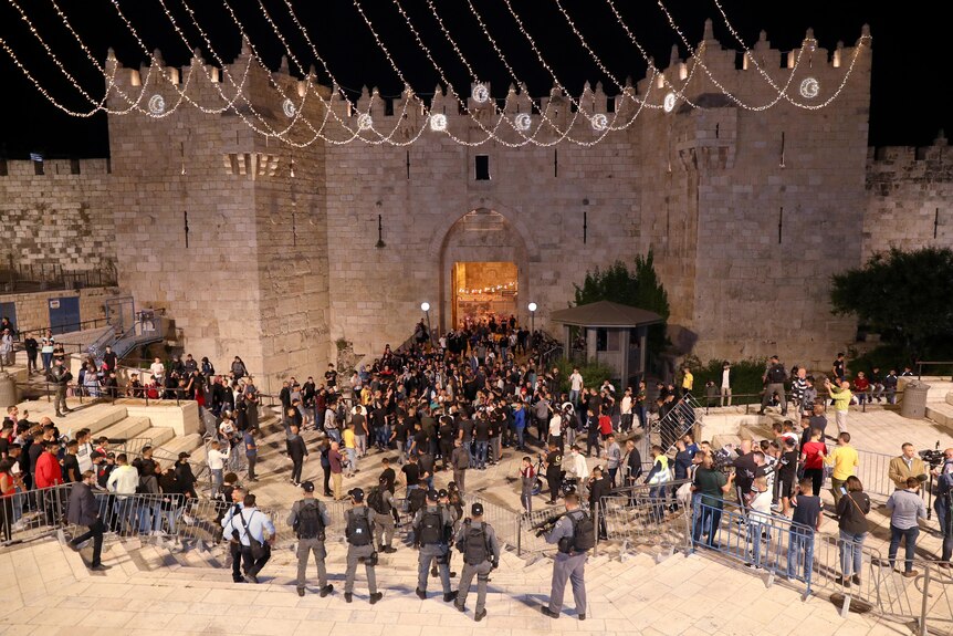 Israeli police and Palestinian men gather near the Damascus Gate