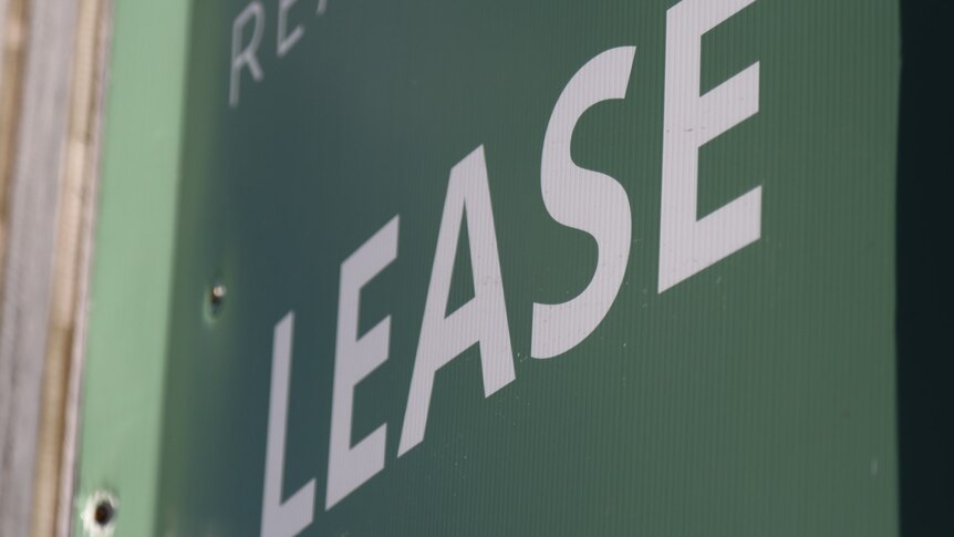 Real estate sign: white "lease" on green background