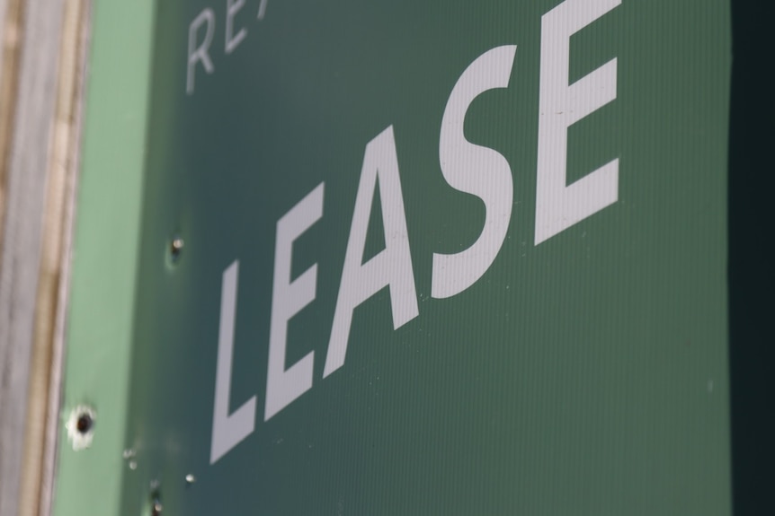 Real estate sign: white "lease" on green background