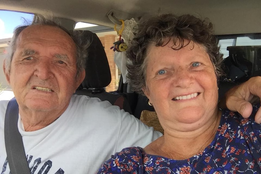 Retired couple Kevin and Pamela Milner grin in a selfie taken from inside their car.