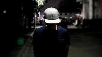 A man stands with his face down in a dark alleyway in Jakarta.