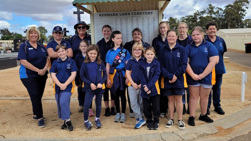 Girl guides lined up in front of a Renmark Lawn Cemetery sign with their leaders