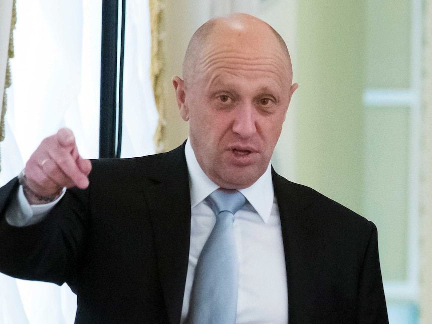 Yevgeny Prigozhin points his finger, his gaze his slightly past the camera