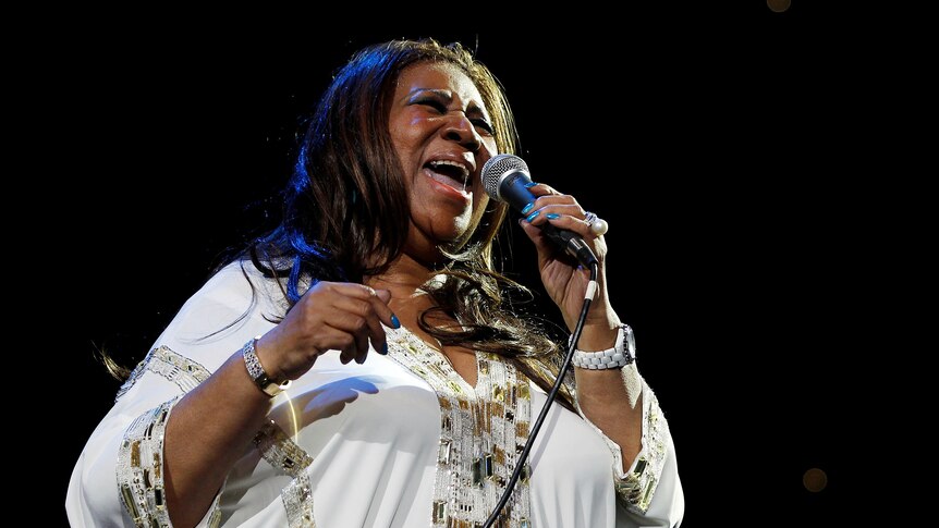 Aretha Franklin sings into a microphone
