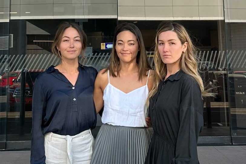Three women and survivors of sexual abuse stand on a flight of stairs leading to the Maroochydore District Court. 