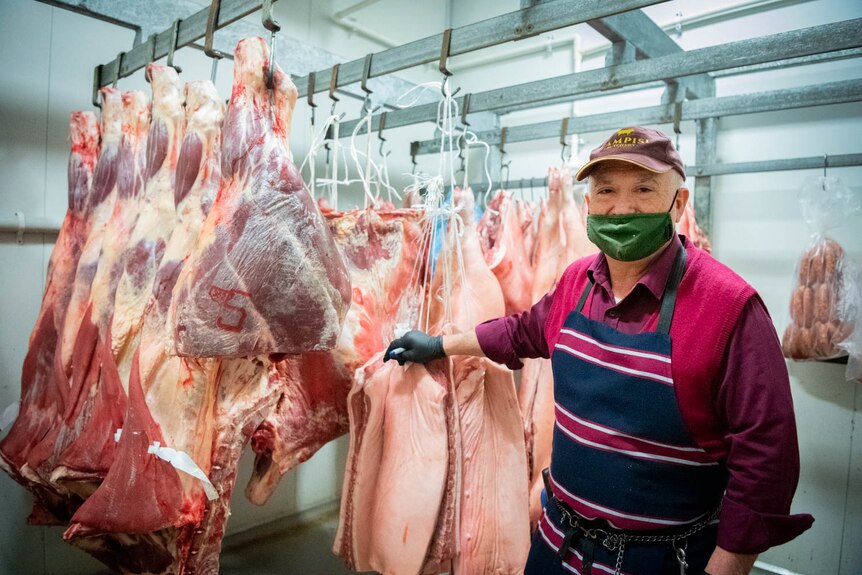 Joe Campisi arranges cuts of meat in a cold room at his butchery.
