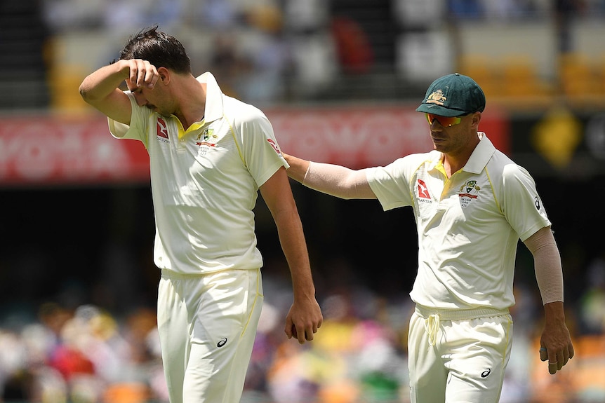 David Warner (R) pats Pat Cummins on the back during day two at the Gabba.