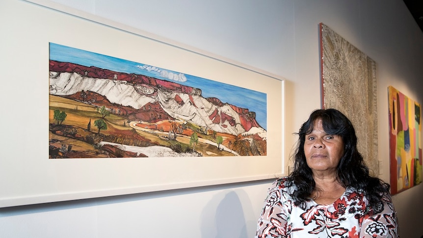 Kathy Inkamala stands by her painting depicting Mount Gillen