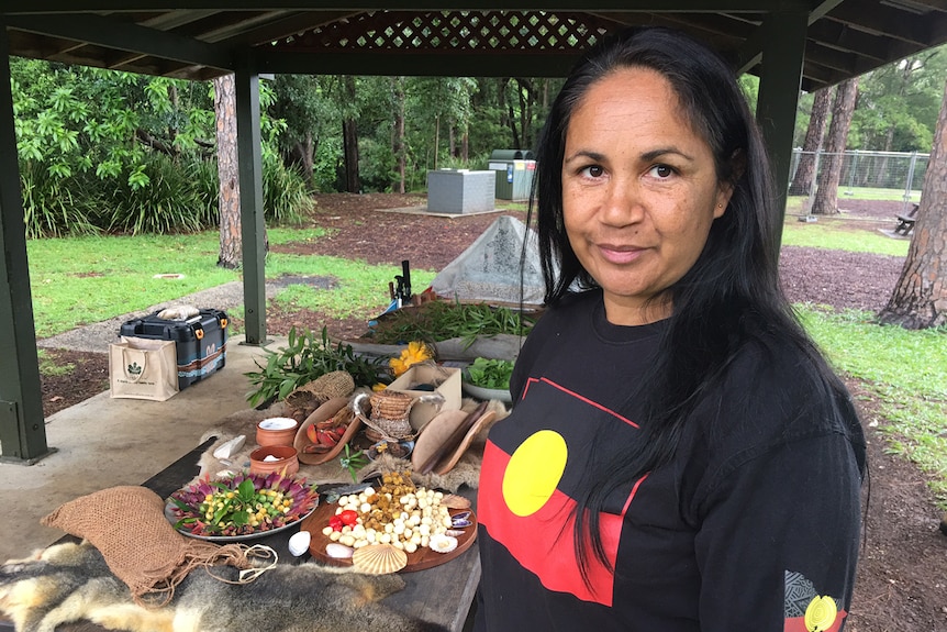 Arakwal elder Delta Kay with a table of native foods in a local park.