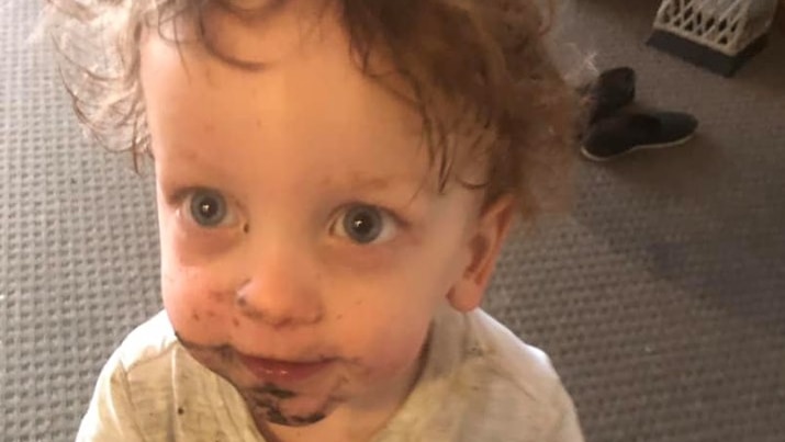 A young toddler with blonde hair and big eyes.