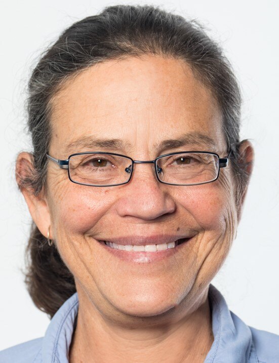 A close-up image of Heather Shearer smiling. Her hair is tied back and she is wearing glasses.