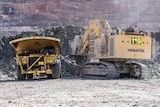 Heavy machinery, including a truck and shovel, inside a gold mine.  