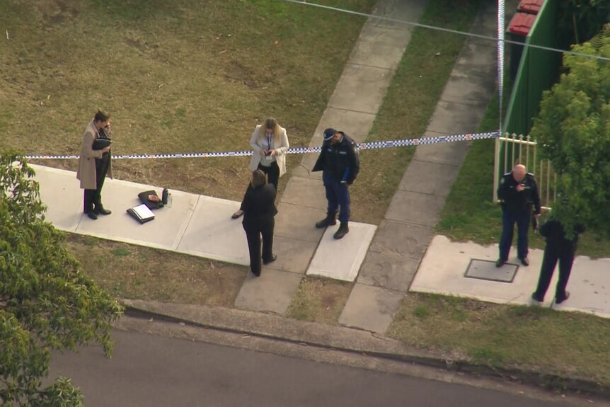 Aerial image of NSW Police Force officers stand near police tape at scene of woman's fatal stabbing in St Marys in Sydney