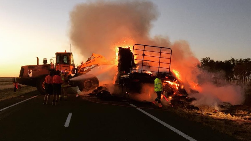 Hay on truck engulfed in flames between kynuna and winton being sprayed by water by Queensland Fire Service