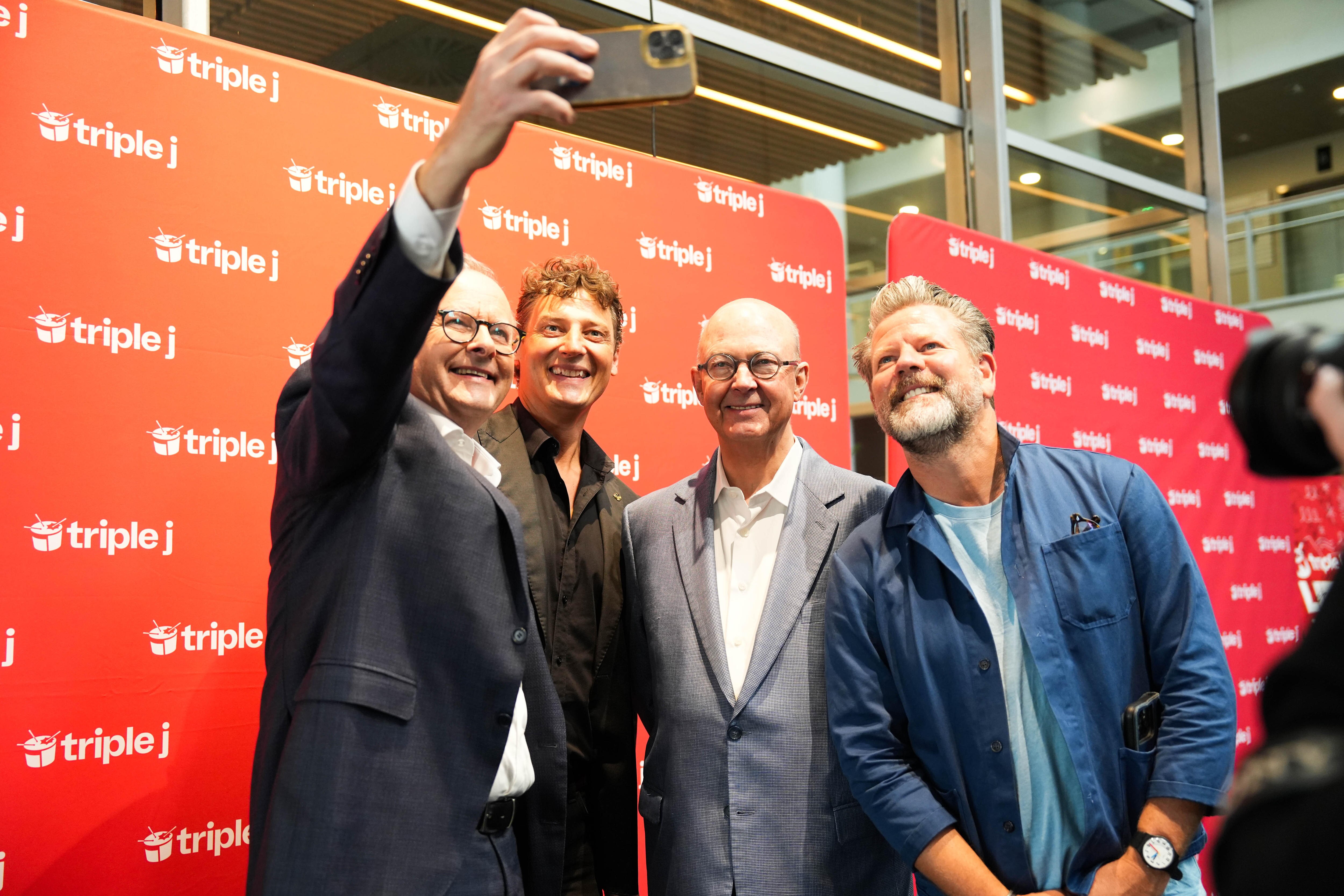 A group of four men take a selfie.