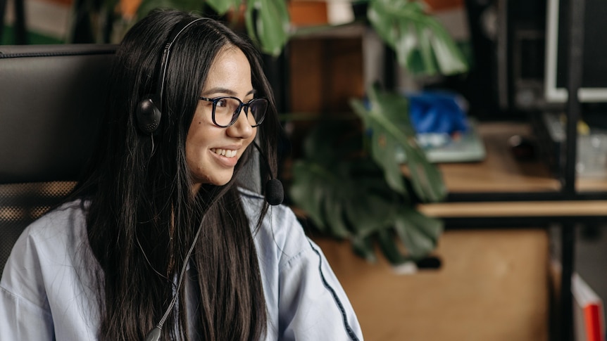 A girl in glasses and a headset smiles, in a story about setting boundaries as a casual worker.
